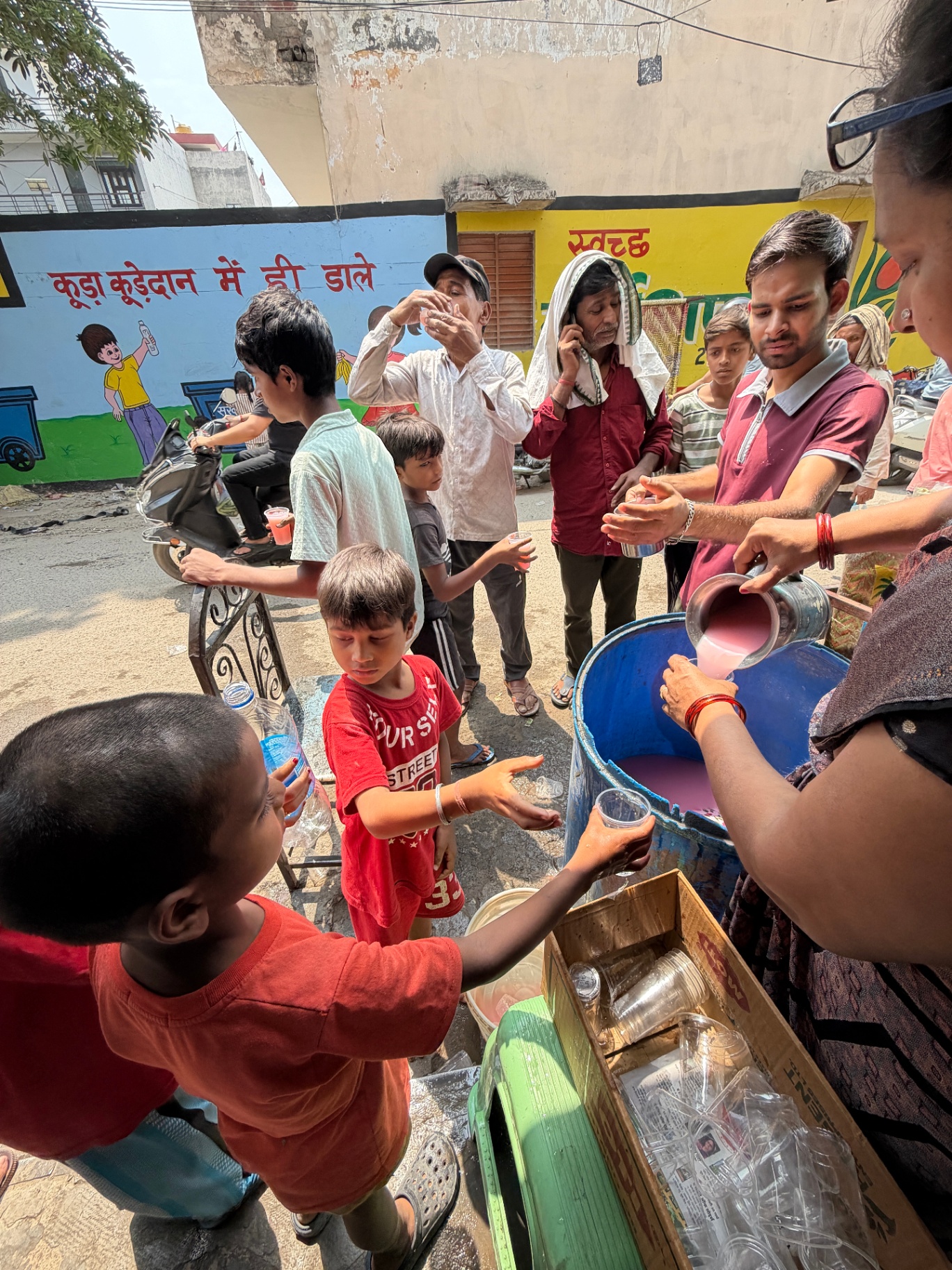 Children and elders receiving Milk Rooh Afza sharbat from Kindpath Foundation volunteers