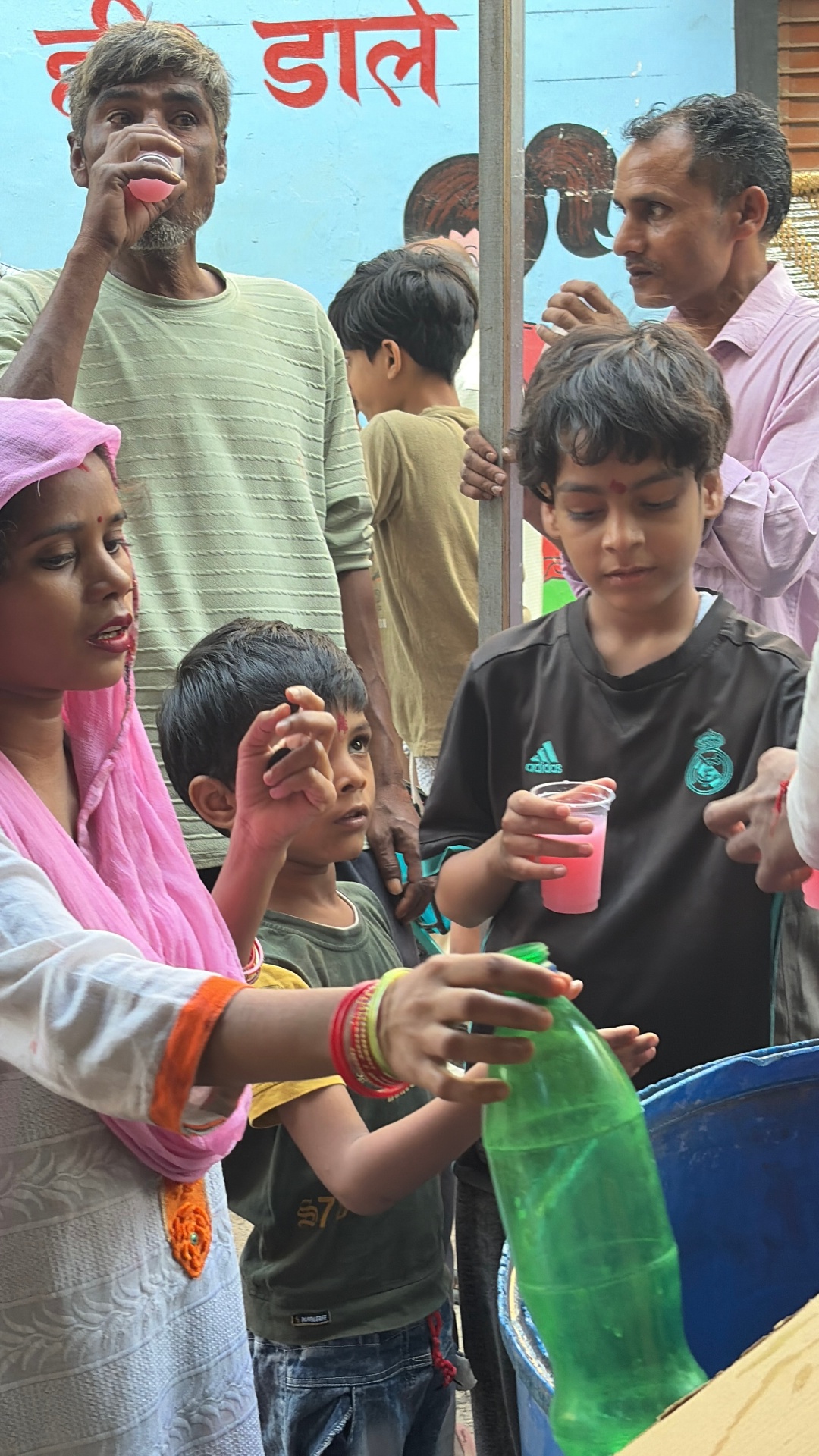 Children and elders receiving Milk Rooh Afza sharbat from Kindpath Foundation volunteers on Somwati Amavasya